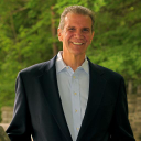 Smiling man in a suit standing outdoors, representing a professional in the accounting and financial services sector in Southern New Hampshire.